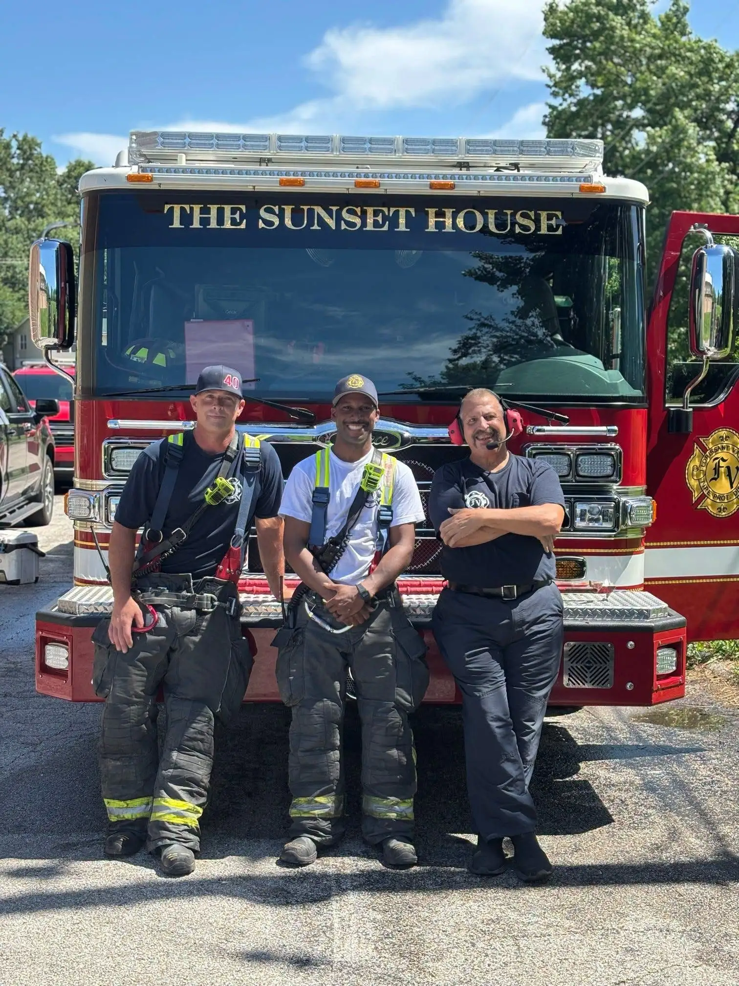 Florissant Valley firefighters standing together in front of a District fire engine