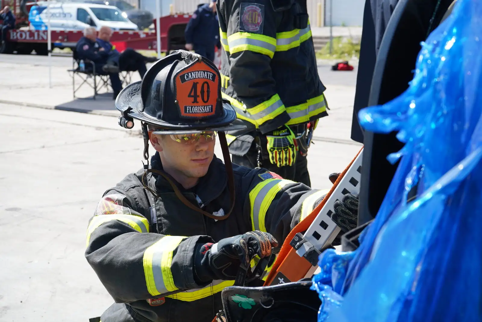A candidate firefighter runs a cutting tool during extrication training