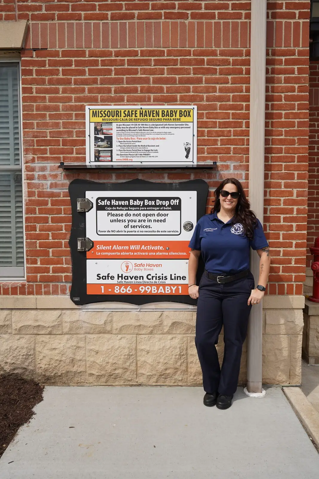 A District firefighter/paramedic beside the Safe Haven Baby Box