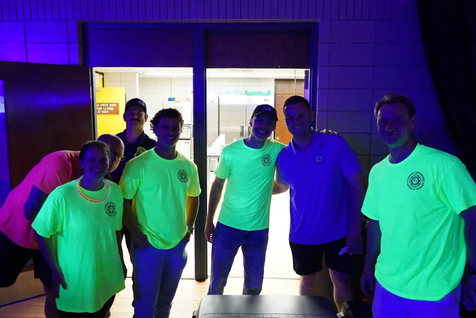The outreach team in neon shirts at the Black Light Bingo Bash