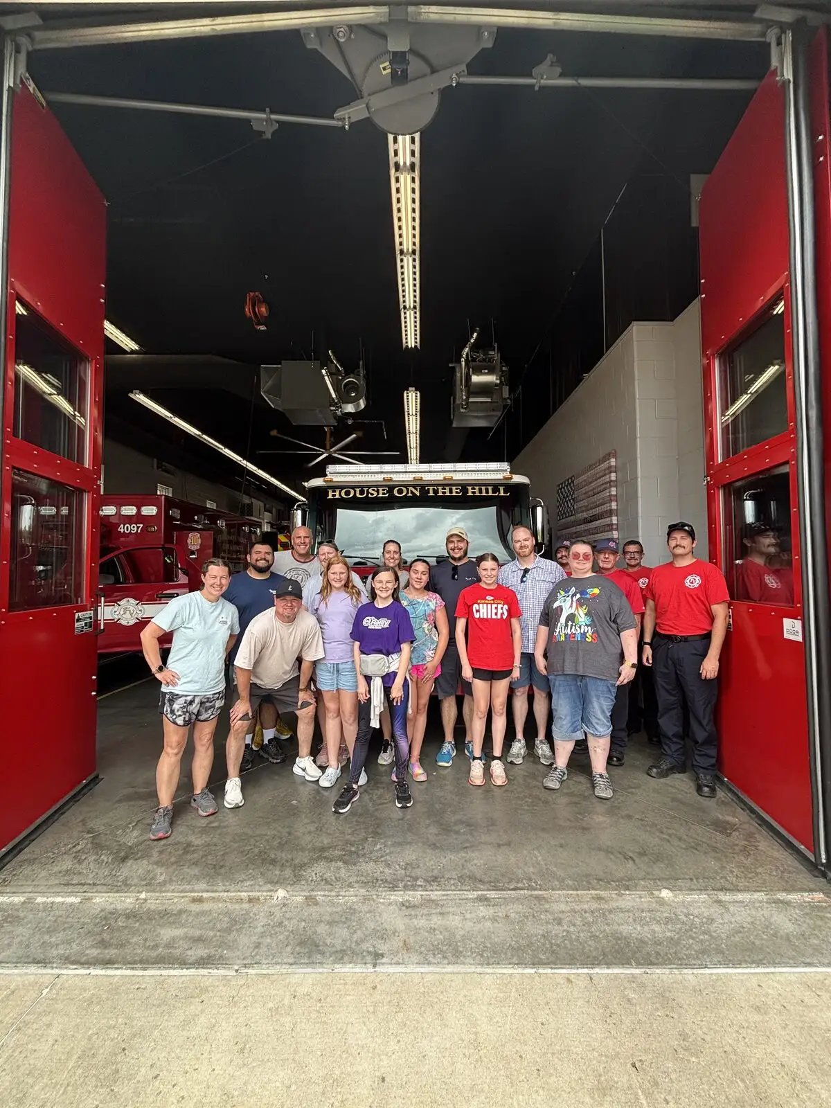 A group gathered in the apparatus bay during a firehouse tour