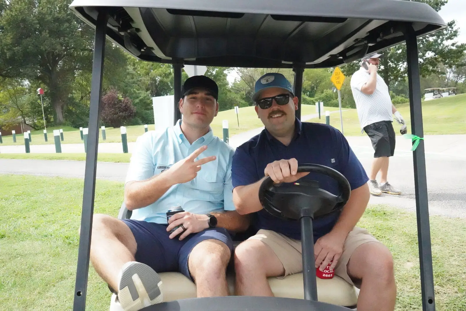Members riding a cart at the annual FFCO golf tournament