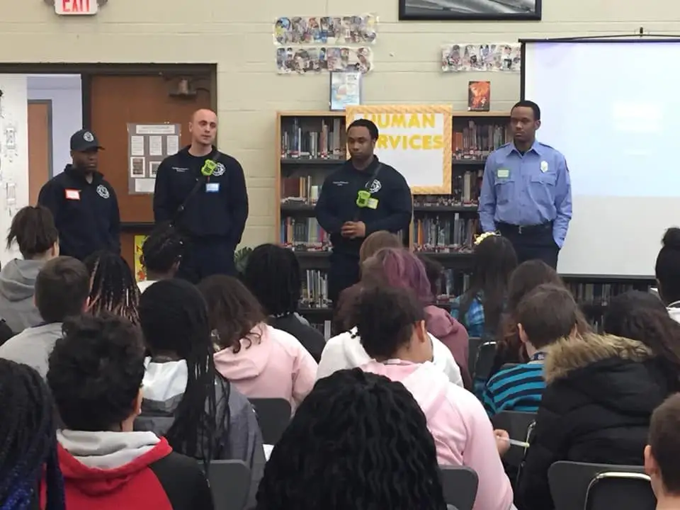 A firefighter speaking to students at a local middle school
