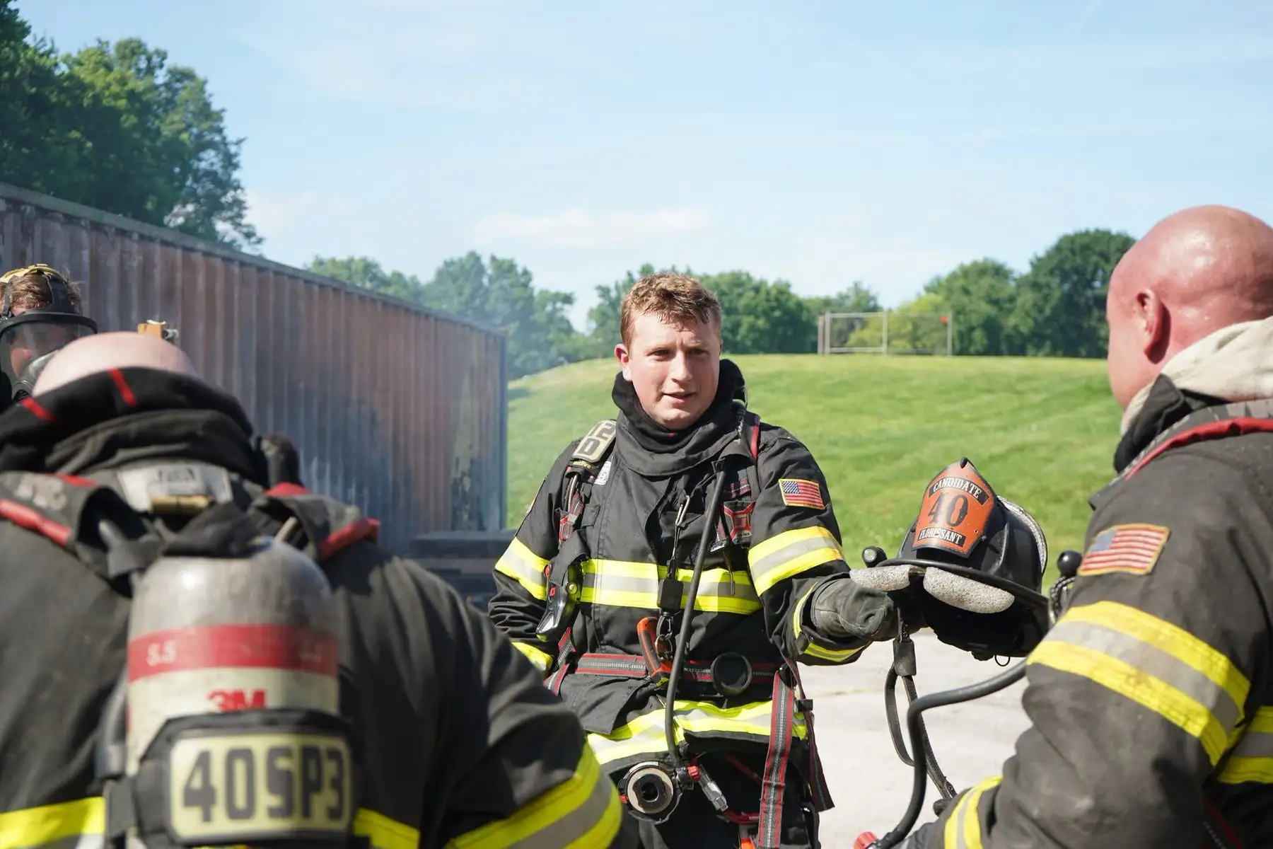 A training officer briefing candidate firefighters before a training evolution