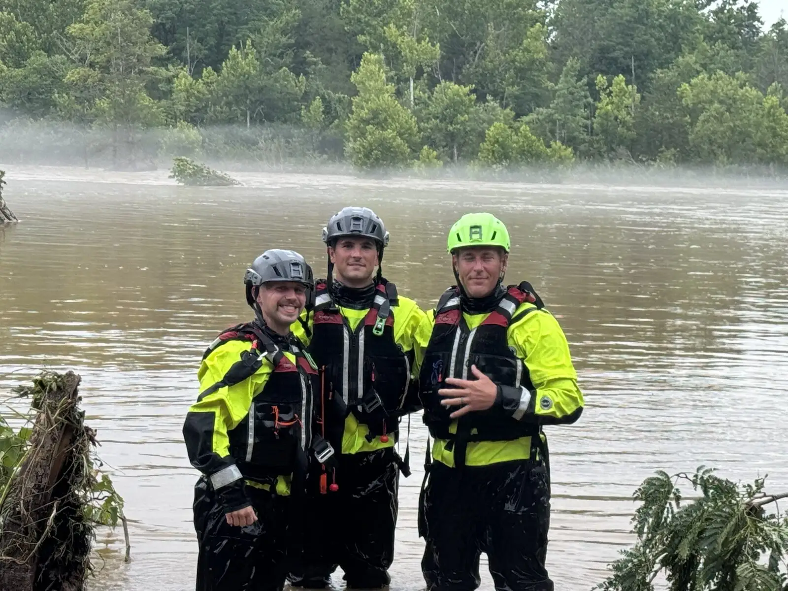 A District water-rescue team in dry suits along a flooded river